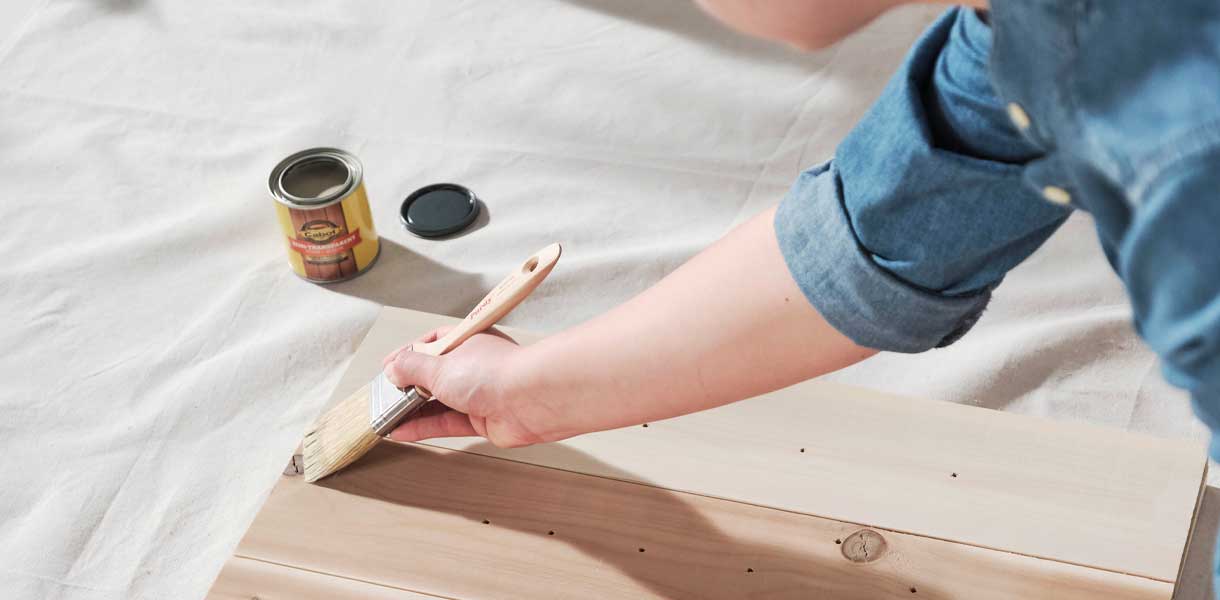 person staining boards
