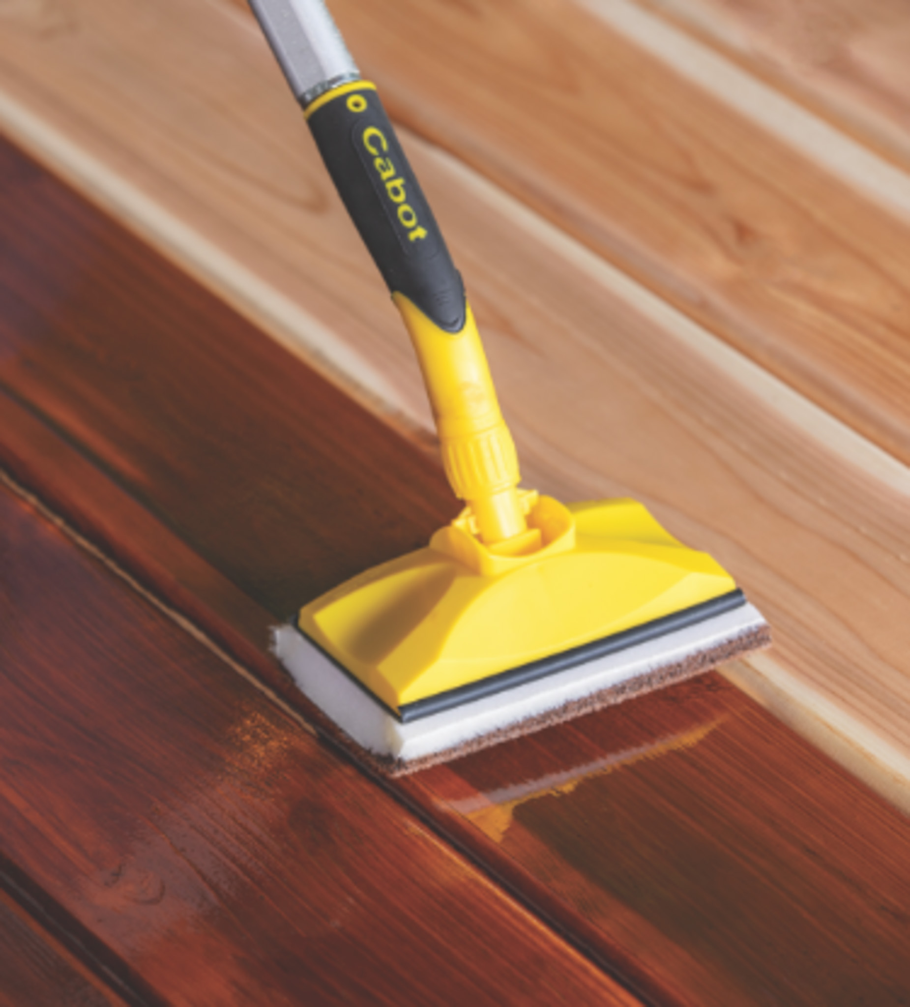 applying stain to a deck with a Cabot applicator