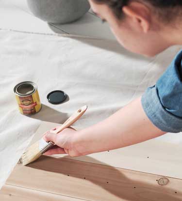 person staining boards