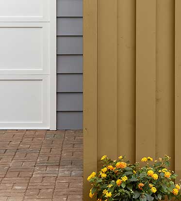 wood house siding with flower bed