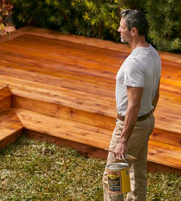 pro admiring a deck they stained