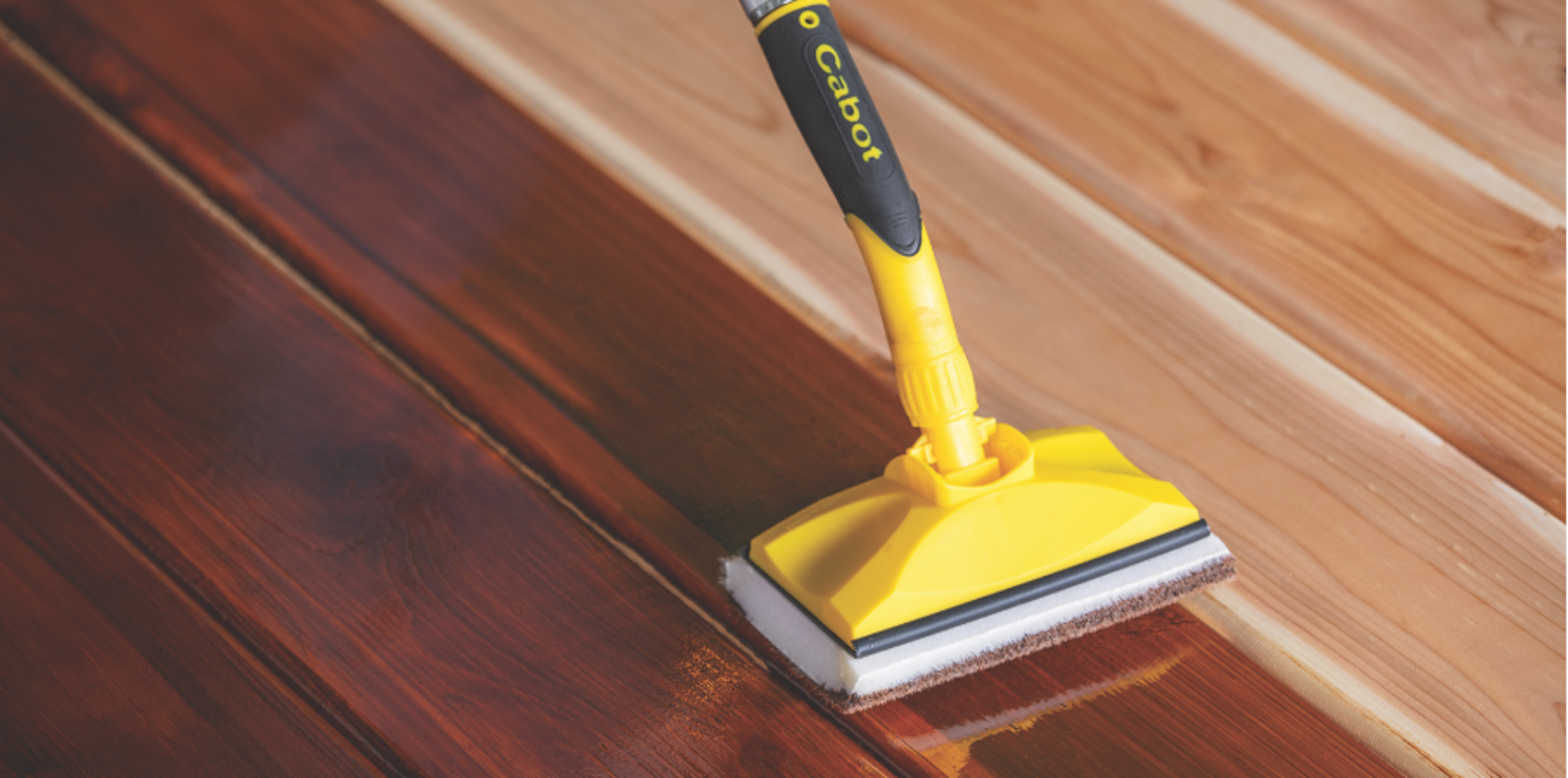 applying stain to a deck with a Cabot applicator